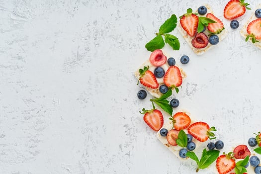 Rise crispbread frame with berries and fruits colorful concept on pastel background photo