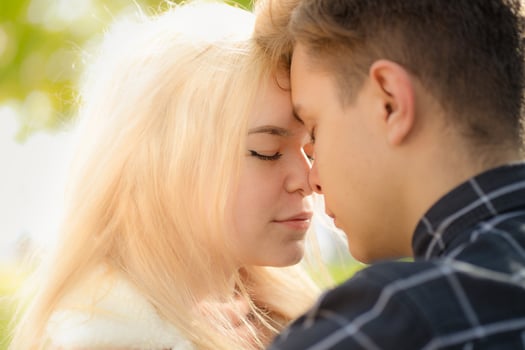 A man affectionately call looks at woman, guy and girl are worth close, touching tips noses. Concept of first teenage love and first kiss. Boy and girl, couple. Intimacy, honesty, trust, open feelings photo