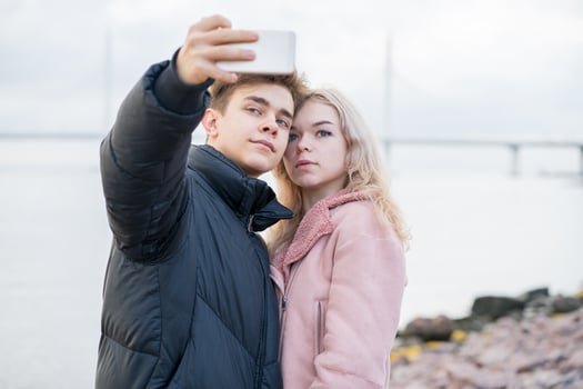 Teenage love concept. Cute brunette guy young blonde girl photo