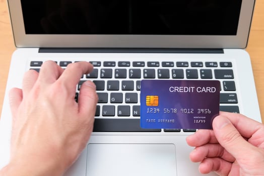 Men hand holding credit card and type payment information on keyboard for order online shopping. Internet technology and Digital market place E-Commerce lifestyle concept, Purchase transaction. photo