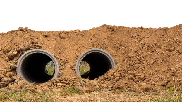 Both concrete pipes are buried in the soil. photo
