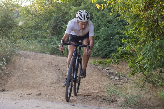 Bicycle rider on professional cyclocross bike ride downhill, pine and lake background photo