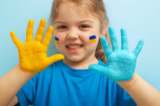 Yellow and blue paint on childrens hands. Ukrainian flag symbols concept photo