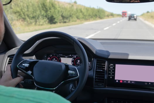 Car interior on the road. Steering wheel, dashboard and on-board display photo