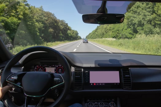 Car interior on the road. Steering wheel, dashboard and on-board display photo