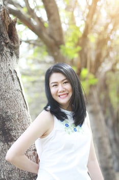 Beautiful asian woman in white dress relax and smiling in natural park. Thai girl or Chinese Girl enjoy on holiday with sunlight in garden photo