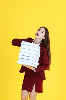 Businesswoman in red suit hand holding document books isolated on yellow background. Copy Space photo