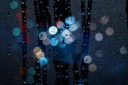 raindrops on the window and street lights at night photo