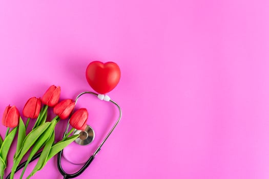 Thank you, doctors and nurses. Selective focus. Happy nurse's day. Health day. Stethoscope, red tulips, on pink background. Greeting background. National doctor's day. Top view, Copy space on right. photo