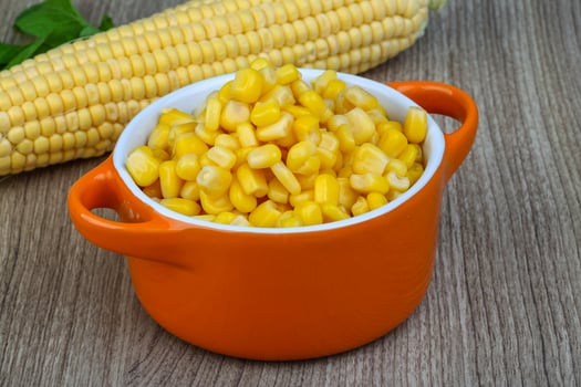 Sweet cornin a bowl on wooden background photo