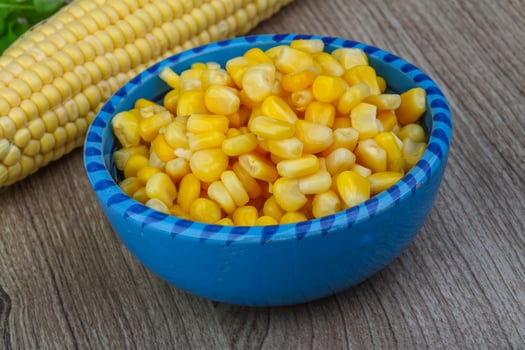 Sweet cornin a bowl on wooden background photo