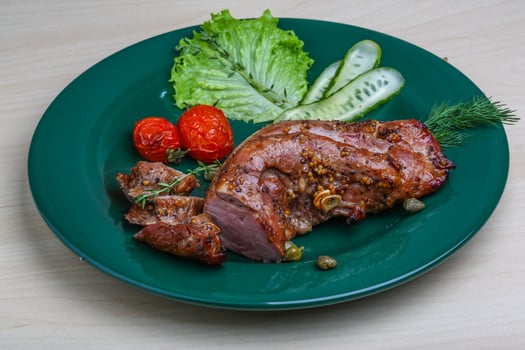 Pork tenderlion on the plate and wooden background photo