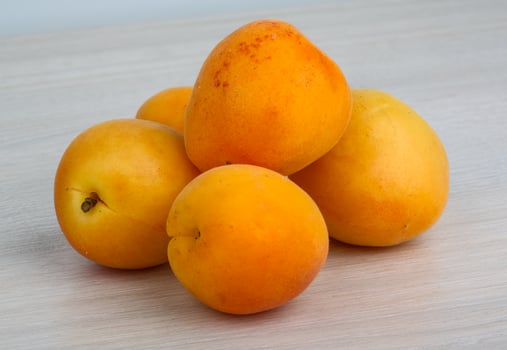 Apricots on wooden background photo