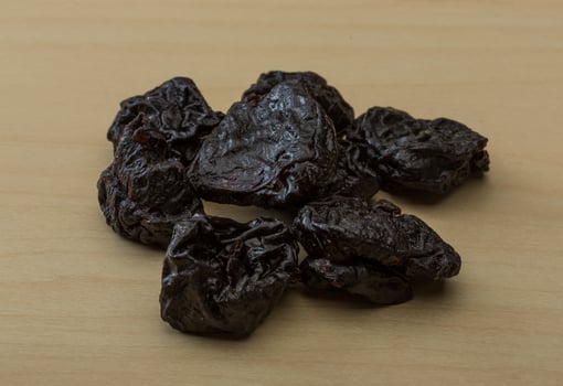Dry plum on wooden background photo