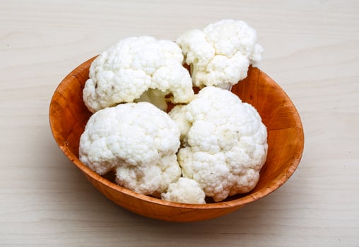Cauliflower in a bowl on wooden background photo