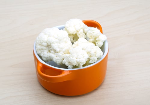 Cauliflower in a bowl on wooden background photo