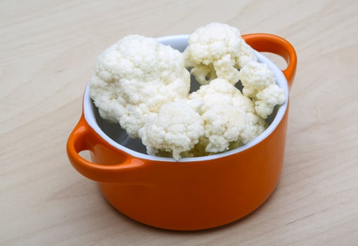 Cauliflower in a bowl on wooden background photo