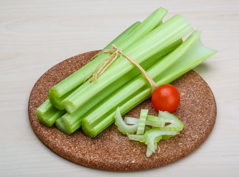 Celery on wooden board and wooden background photo