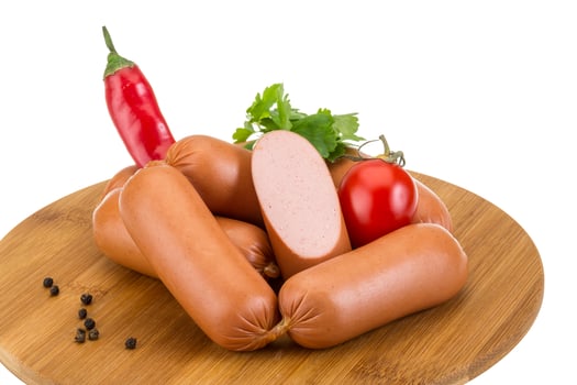 Sausages on wooden board and white background photo