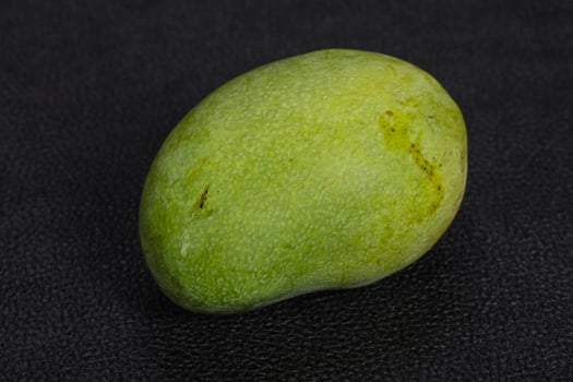 Green tasty mango over wooden background photo