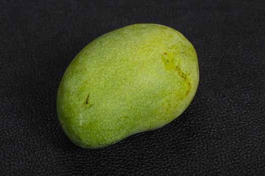 Green tasty mango over wooden background photo