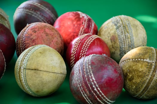 Closeup old and used leather cricket balls on green floor, soft and selective focus. concept for cricket lover around the world. photo