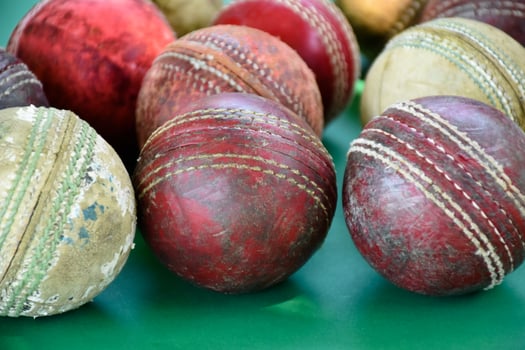 Closeup old and used leather cricket balls on green floor, soft and selective focus. concept for cricket lover around the world. photo