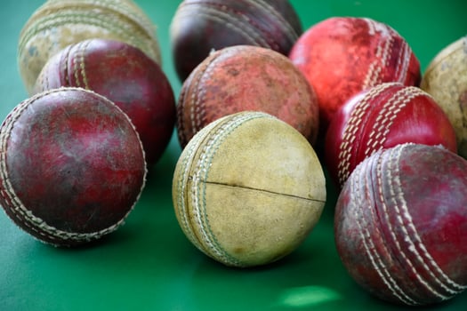 Closeup old and used leather cricket balls on green floor, soft and selective focus. concept for cricket lover around the world. photo