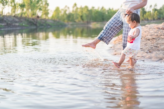 A young mother plays with her 2-5 year old daughter on the beach in summer. Outdoor resort on the lake Have a good rest on weekends, family days. photo