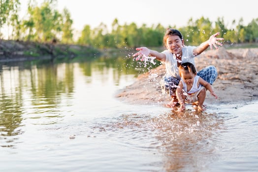 A young mother plays with her 2-5 year old daughter on the beach in summer. Outdoor resort on the lake Have a good rest on weekends, family days. photo