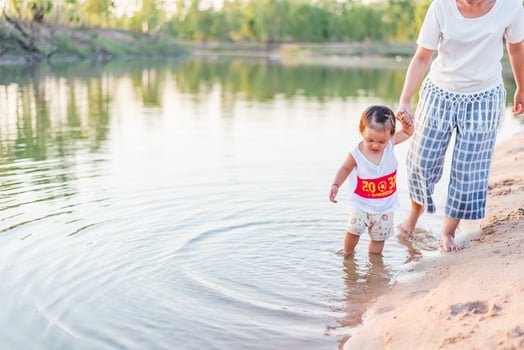 A young mother plays with her 2-5 year old daughter on the beach in summer. Outdoor resort on the lake Have a good rest on weekends, family days. photo