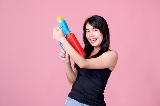 Beautiful Asian women hold plastic water guns at an ancient temple during Songkran, the most beautiful and fun water festival in Thailand photo