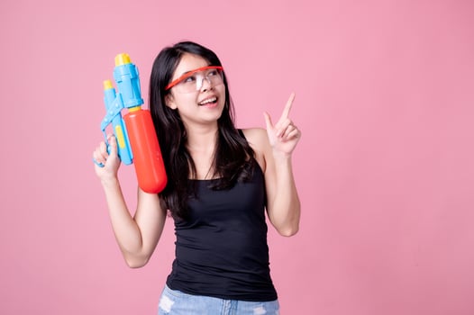 Beautiful Asian women hold plastic water guns at an ancient temple during Songkran, the most beautiful and fun water festival in Thailand photo