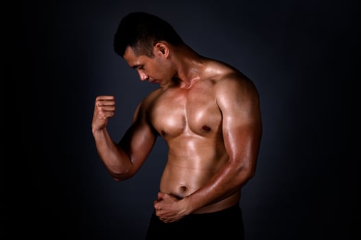 A strong Asian man raised his arms to show his strong and beautiful muscles from exercise photo