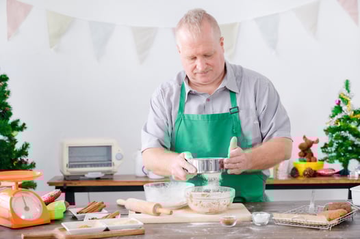 A European dad sifted flour and prepared ingredients for baking gingerbread, which he and his family made for Christmas and New Year photo