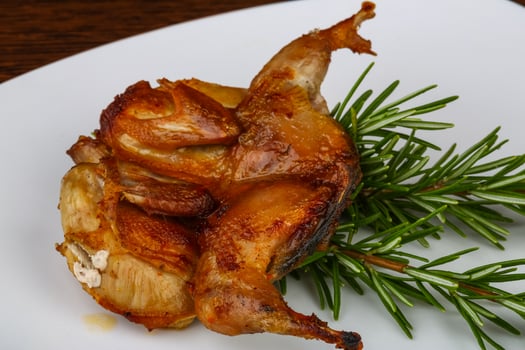 Grilled quail on the plate and white background photo