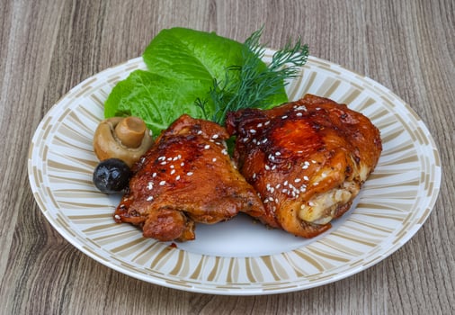 Teriyaki chicken on the plate and wooden background photo