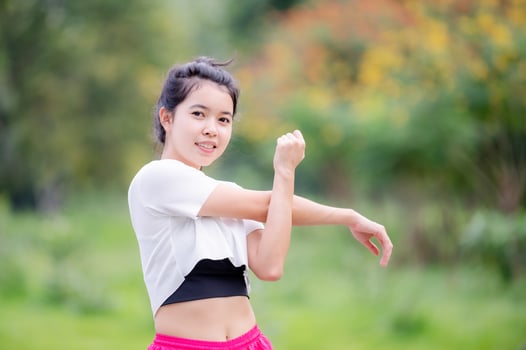 A beautiful Asian woman is warm up, To make the muscles flexible Before going to jogging photo