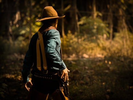 The senior cowboy stands preparing for a gunfight against opponents in the outlawed western lands photo