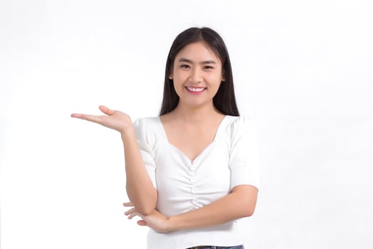 Asian girl with black long hair wearing a white shirt and pretty smiling is present product on white background. photo