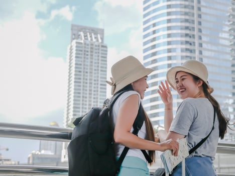 Couple backpackers with suitcase are smiling in happy moments at Bangkok city outdoor, inspirational travel concept. photo