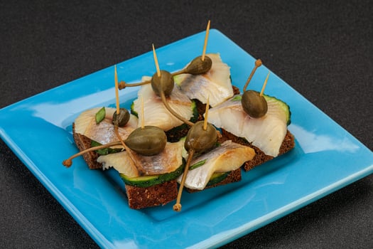 Herring fillet canape with caperberry photo