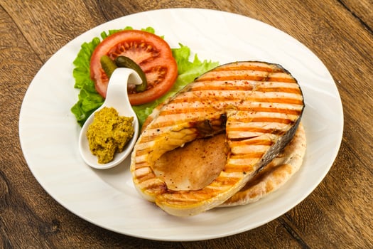 Grilled salmon on the plate and wooden background photo