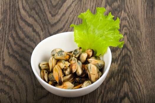 Pickled mussels in a bowl on wooden background photo