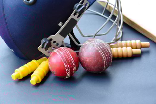 Old training cricket sport equipments on dark floor, leather ball, wickets, helmet and wooden bat, soft and selective focus, traditional cricket sport lovers around the world concept. photo