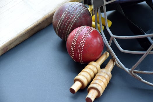 Old training cricket sport equipments on dark floor, leather ball, wickets, helmet and wooden bat, soft and selective focus, traditional cricket sport lovers around the world concept. photo