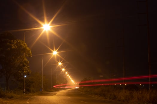 Lighting lamps and car lights on country roads at night. photo