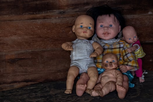 A group of baby dolls sitting in an old wooden house. photo