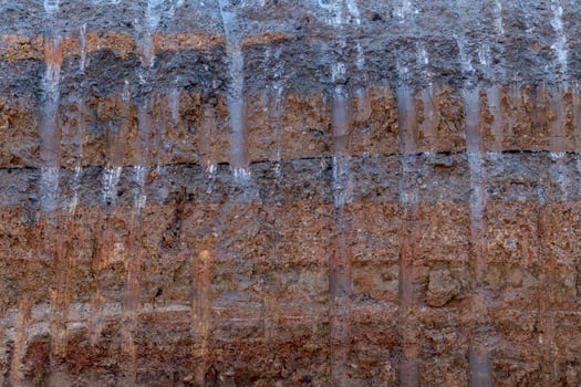 Surface soil layer under the road with digging trails. photo