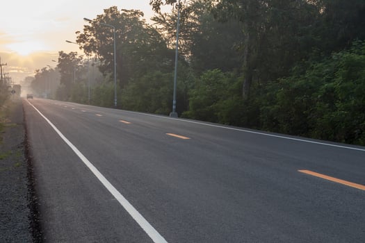 Asphalt road with sun rising in the countryside. photo